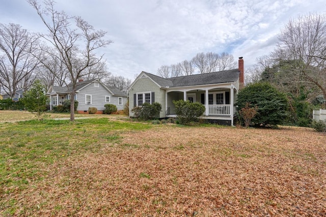 view of front of house with crawl space, a porch, a front lawn, and a chimney