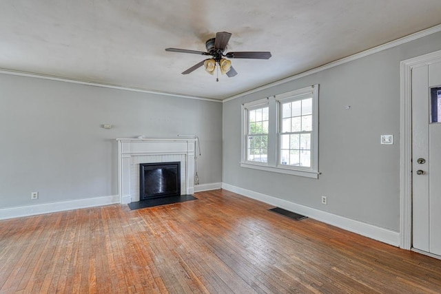 unfurnished living room featuring baseboards, crown molding, visible vents, and hardwood / wood-style floors