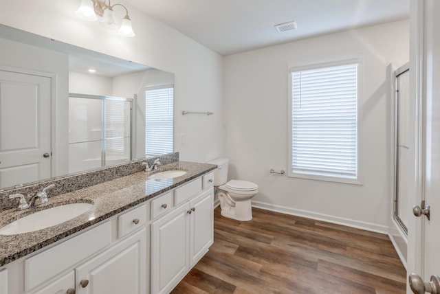 bathroom with a stall shower, visible vents, a sink, and wood finished floors