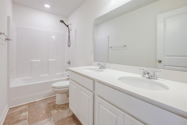 bathroom featuring toilet, double vanity, shower / washtub combination, and a sink