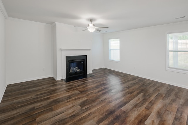 unfurnished living room with dark wood-style floors, visible vents, a fireplace with flush hearth, ornamental molding, and baseboards