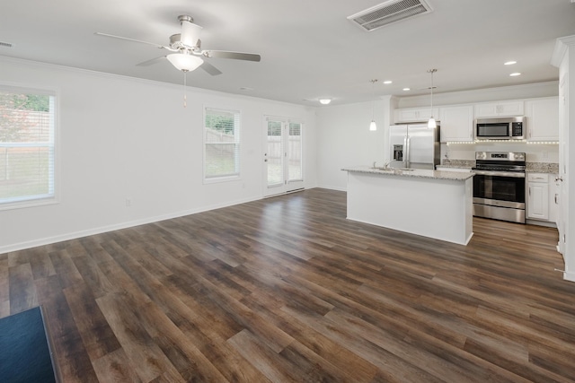 kitchen with stainless steel appliances, a healthy amount of sunlight, visible vents, and ornamental molding