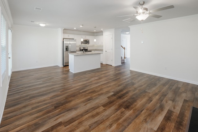 unfurnished living room with visible vents, ornamental molding, and dark wood-type flooring