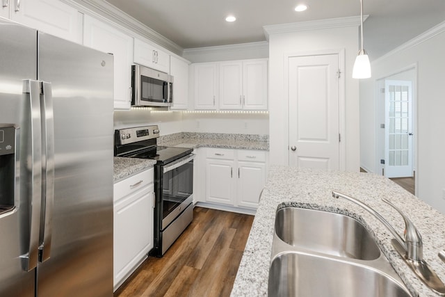 kitchen with white cabinets, dark wood-style floors, ornamental molding, stainless steel appliances, and a sink