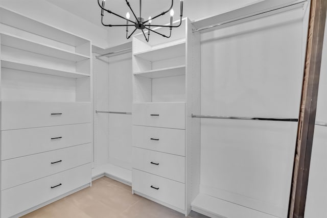 walk in closet with an inviting chandelier