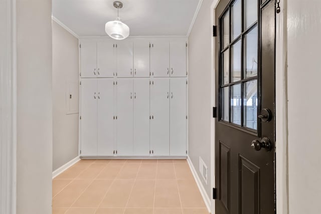 doorway to outside featuring ornamental molding, visible vents, baseboards, and light tile patterned floors