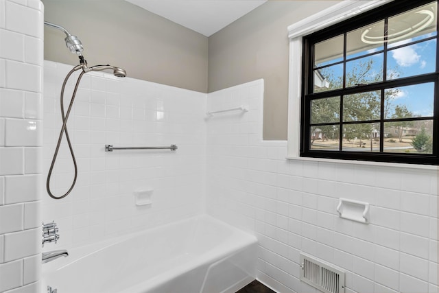 full bathroom with visible vents, tile walls, and shower / bathtub combination