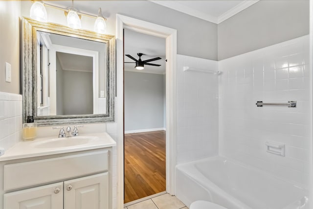 bathroom featuring ornamental molding, a ceiling fan, tub / shower combination, vanity, and tile patterned flooring