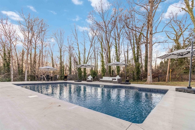 pool featuring outdoor dining area, a patio area, fence, and an outdoor living space