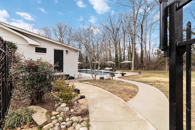 exterior space featuring a patio area, fence, and an outdoor pool