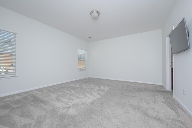 unfurnished room featuring carpet floors and baseboards