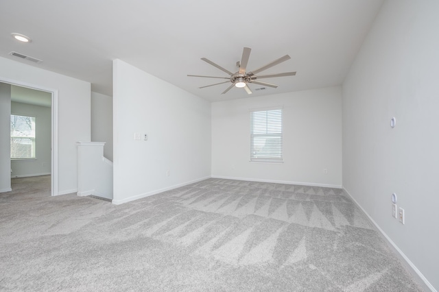 spare room featuring carpet flooring, visible vents, and baseboards