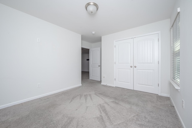 unfurnished bedroom featuring carpet floors, a closet, and baseboards