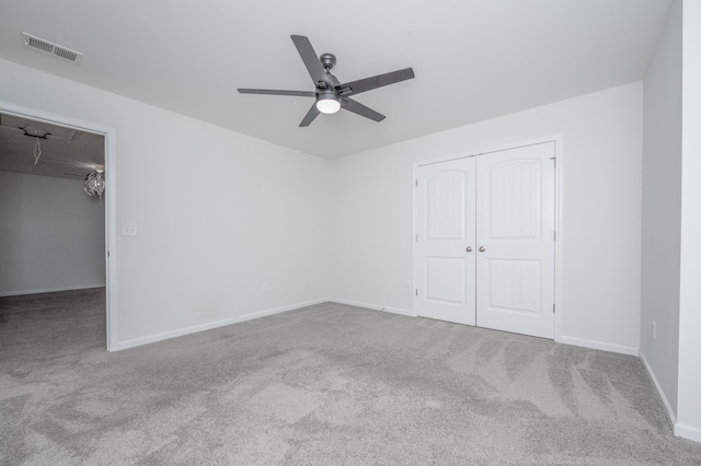 unfurnished bedroom with a closet, visible vents, attic access, carpet flooring, and baseboards