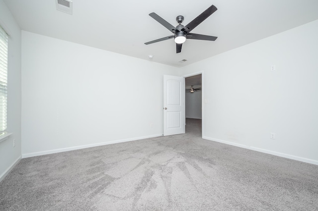 unfurnished room featuring baseboards, visible vents, ceiling fan, and carpet flooring