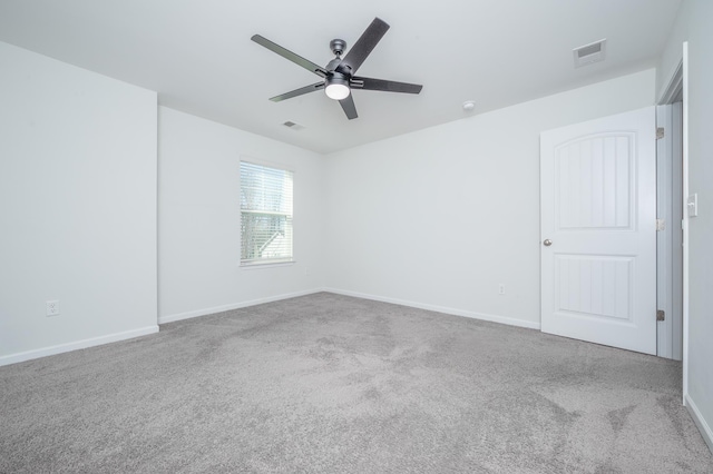 empty room with a ceiling fan, carpet, visible vents, and baseboards