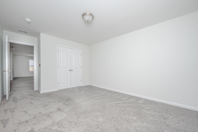 unfurnished bedroom featuring a closet, carpet flooring, visible vents, and baseboards