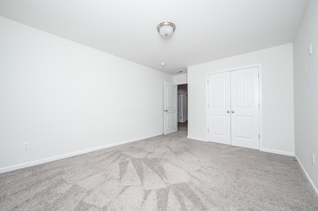 unfurnished bedroom with a closet, carpet, and baseboards