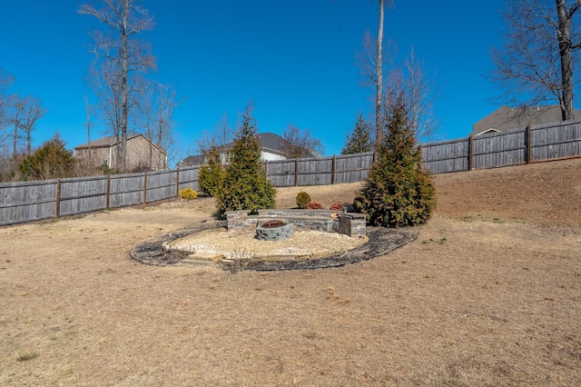 view of yard with a fenced backyard and a fire pit