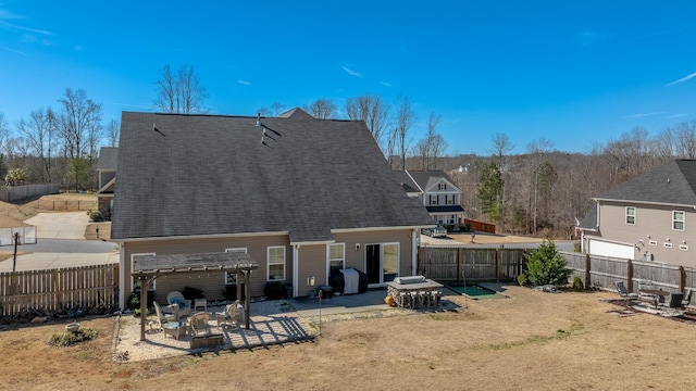 rear view of property featuring a patio, a shingled roof, a fenced backyard, and a pergola