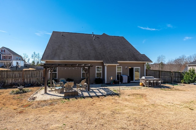 rear view of house with a lawn, an outdoor fire pit, a patio area, fence, and a pergola