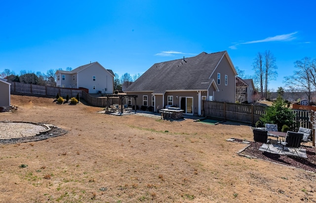 back of property with a fenced backyard, a patio, and a pergola