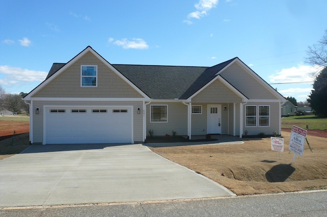 view of front of property with concrete driveway and a shingled roof