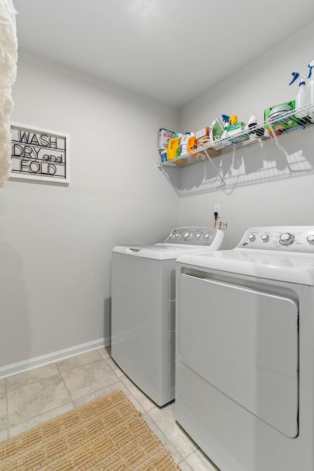 laundry area with laundry area, washer and clothes dryer, and baseboards