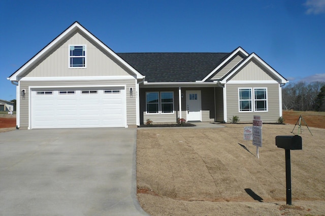 view of front of home with concrete driveway and roof with shingles