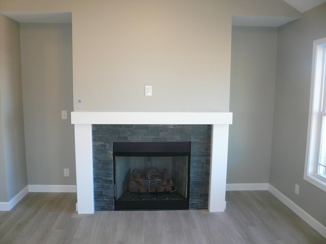 details featuring a fireplace, baseboards, and wood finished floors