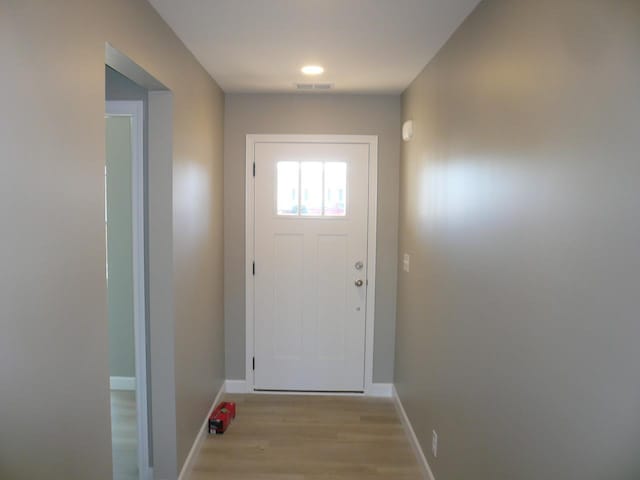 entryway with visible vents, light wood-style flooring, and baseboards