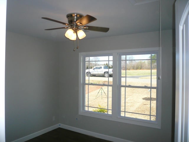 spare room with baseboards, ceiling fan, and a healthy amount of sunlight