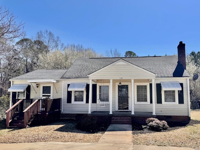 bungalow featuring crawl space, covered porch, a chimney, and roof with shingles