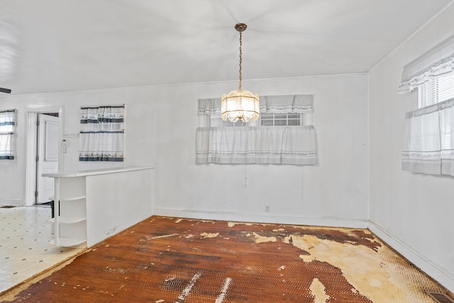 unfurnished dining area with wood finished floors, visible vents, and an inviting chandelier