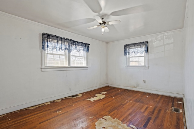 spare room featuring ornamental molding, hardwood / wood-style flooring, visible vents, and a ceiling fan