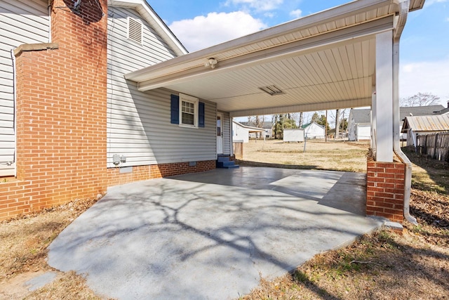 view of patio with a carport, entry steps, and concrete driveway