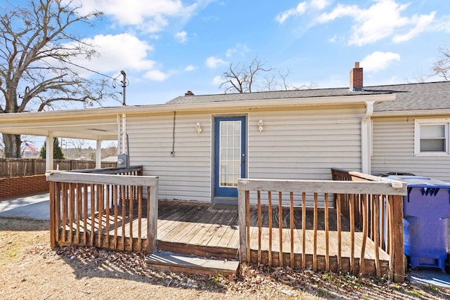 back of house featuring a deck, a shingled roof, a chimney, and fence