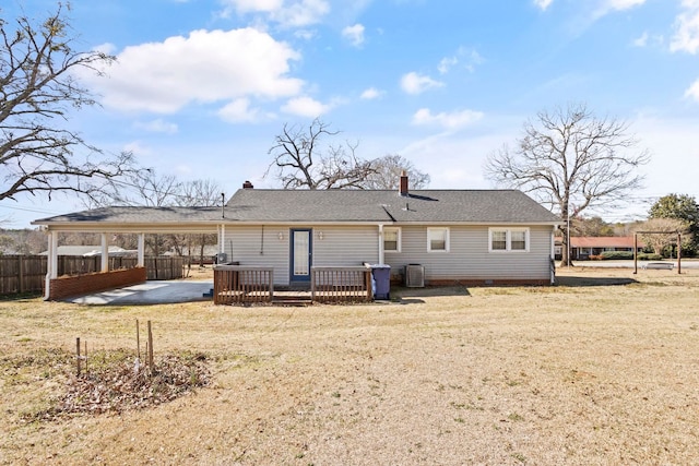 rear view of house featuring central air condition unit, a shingled roof, a lawn, fence, and a carport