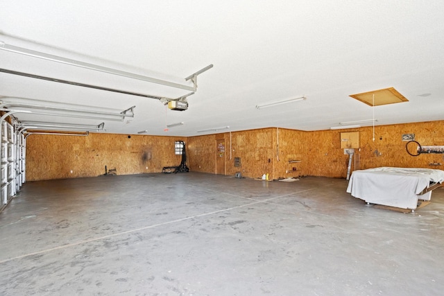 garage featuring wooden walls and a garage door opener