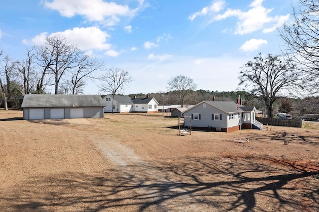 view of yard featuring an outbuilding, a detached garage, and fence