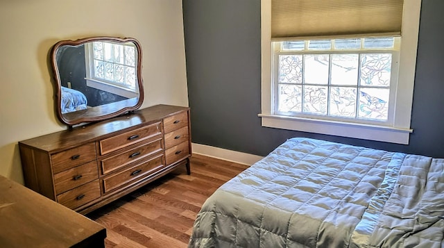 bedroom featuring dark wood-type flooring, multiple windows, and baseboards