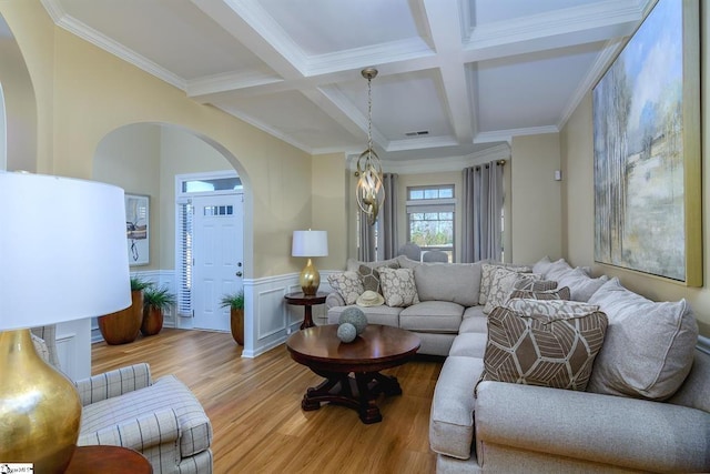 living room featuring wainscoting, visible vents, beamed ceiling, and wood finished floors