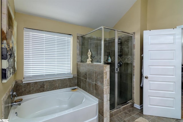 bathroom with a stall shower, tile patterned flooring, and a bath