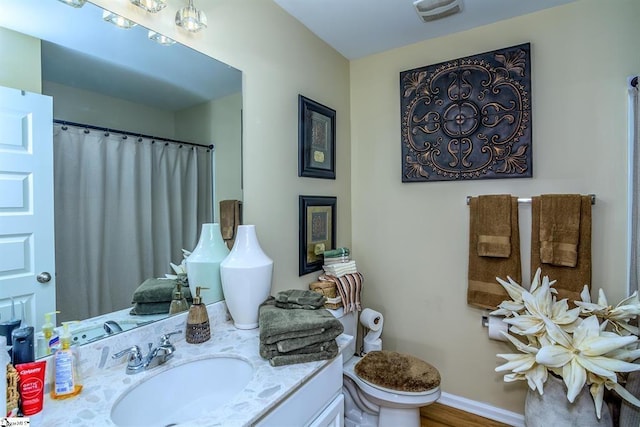 full bathroom with curtained shower, visible vents, toilet, vanity, and baseboards