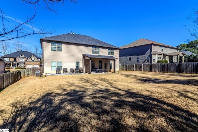 back of house featuring a yard, a fenced backyard, and a patio