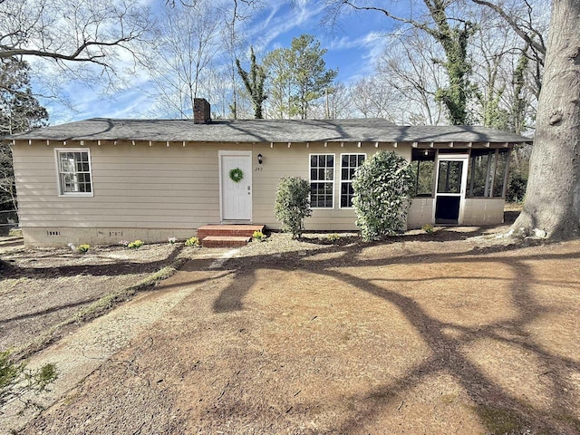 view of front facade featuring crawl space and a chimney
