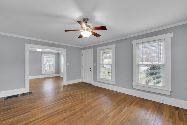 entryway featuring hardwood / wood-style flooring, baseboards, visible vents, and crown molding