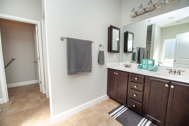 bathroom featuring visible vents, a sink, baseboards, and double vanity