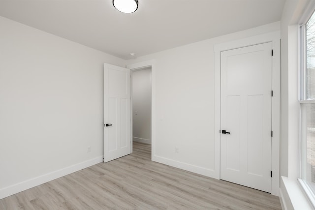 unfurnished bedroom featuring light wood finished floors and baseboards