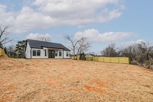 view of front of home featuring a shingled roof and fence